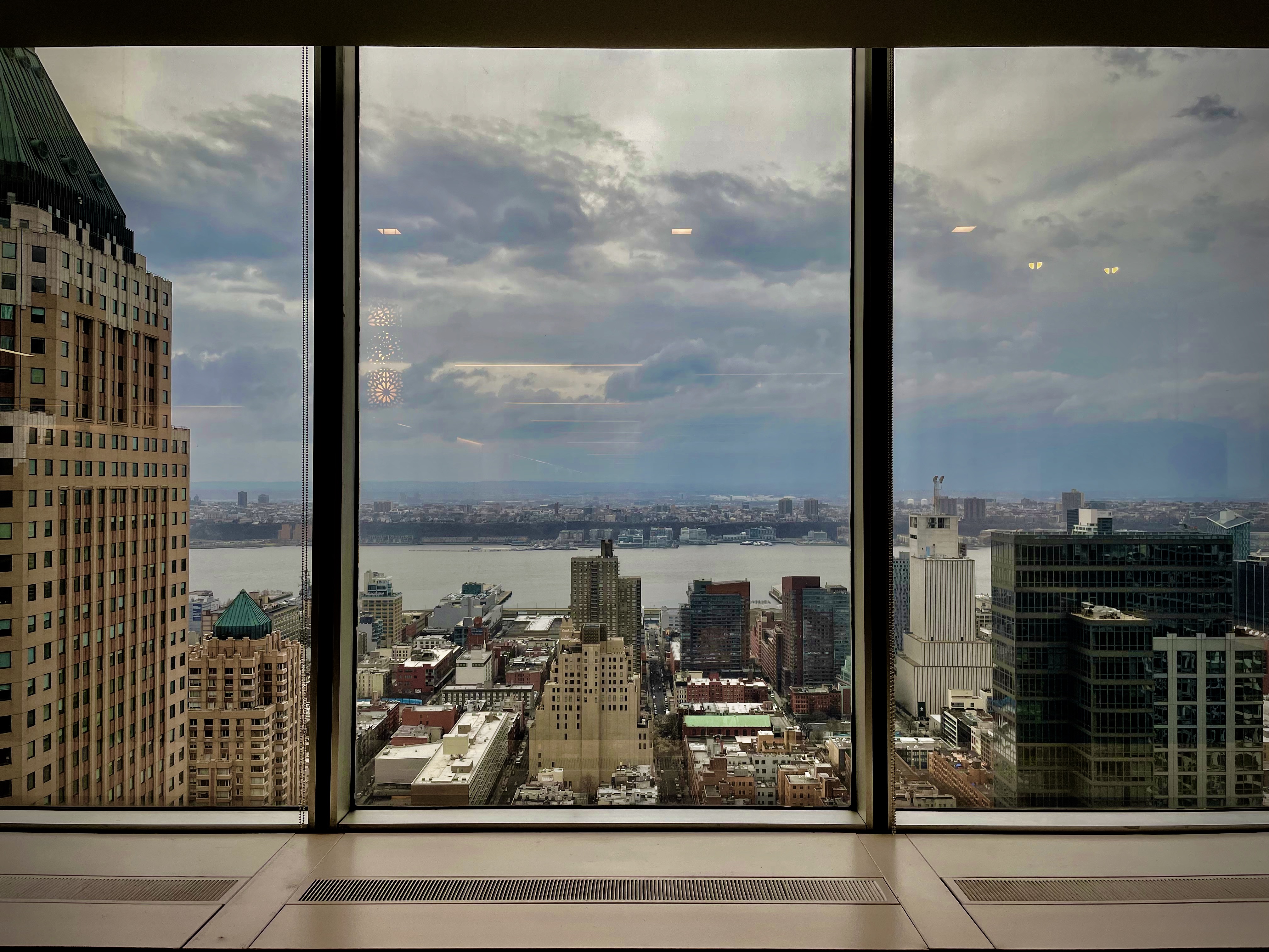 View of Manhattan and Hudson River, through office windows from high in a skyscraper.
