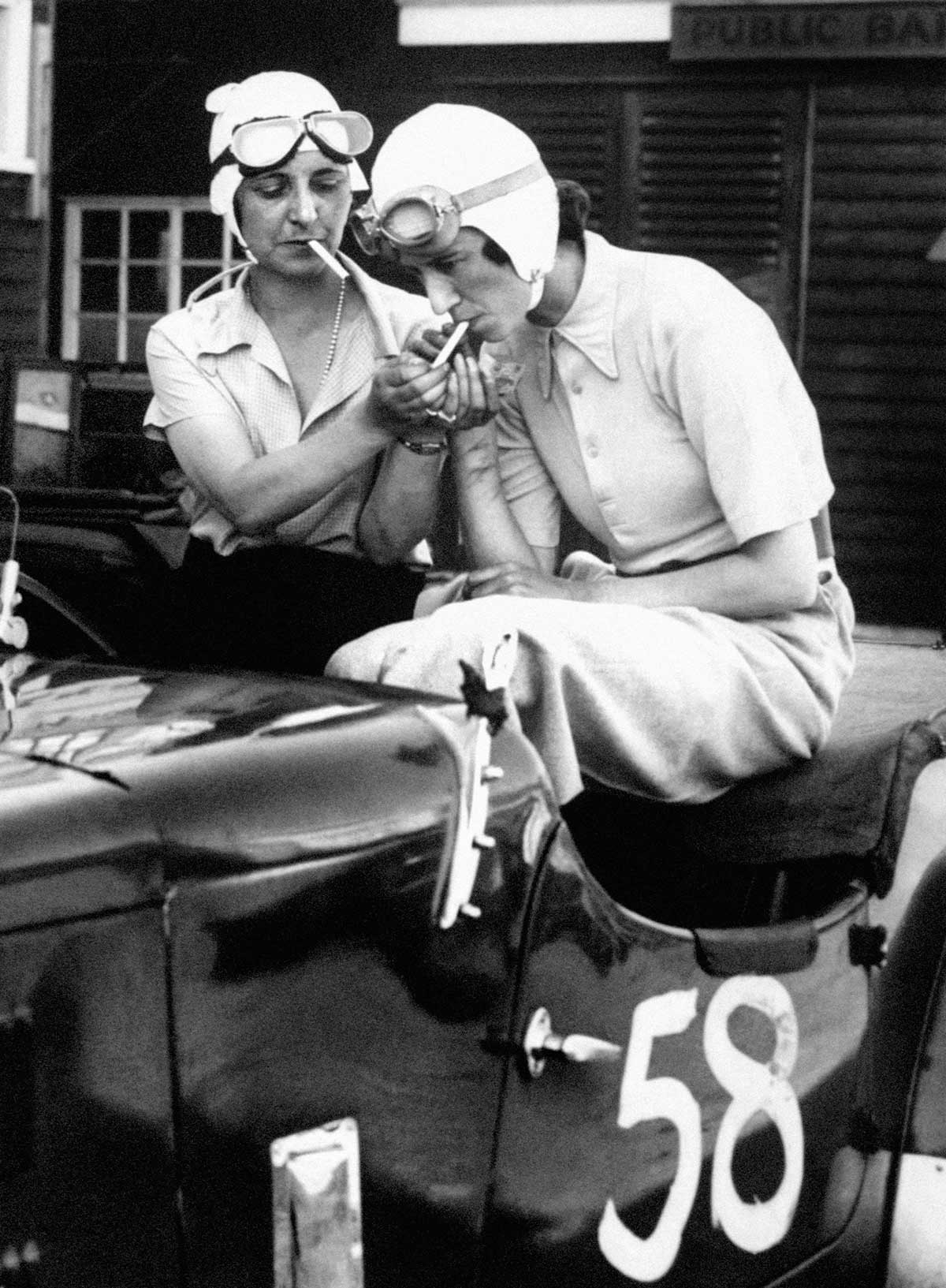 Mrs Gordon Simpson and Joan Richmond smoke cigarettes in their rally car, 1934