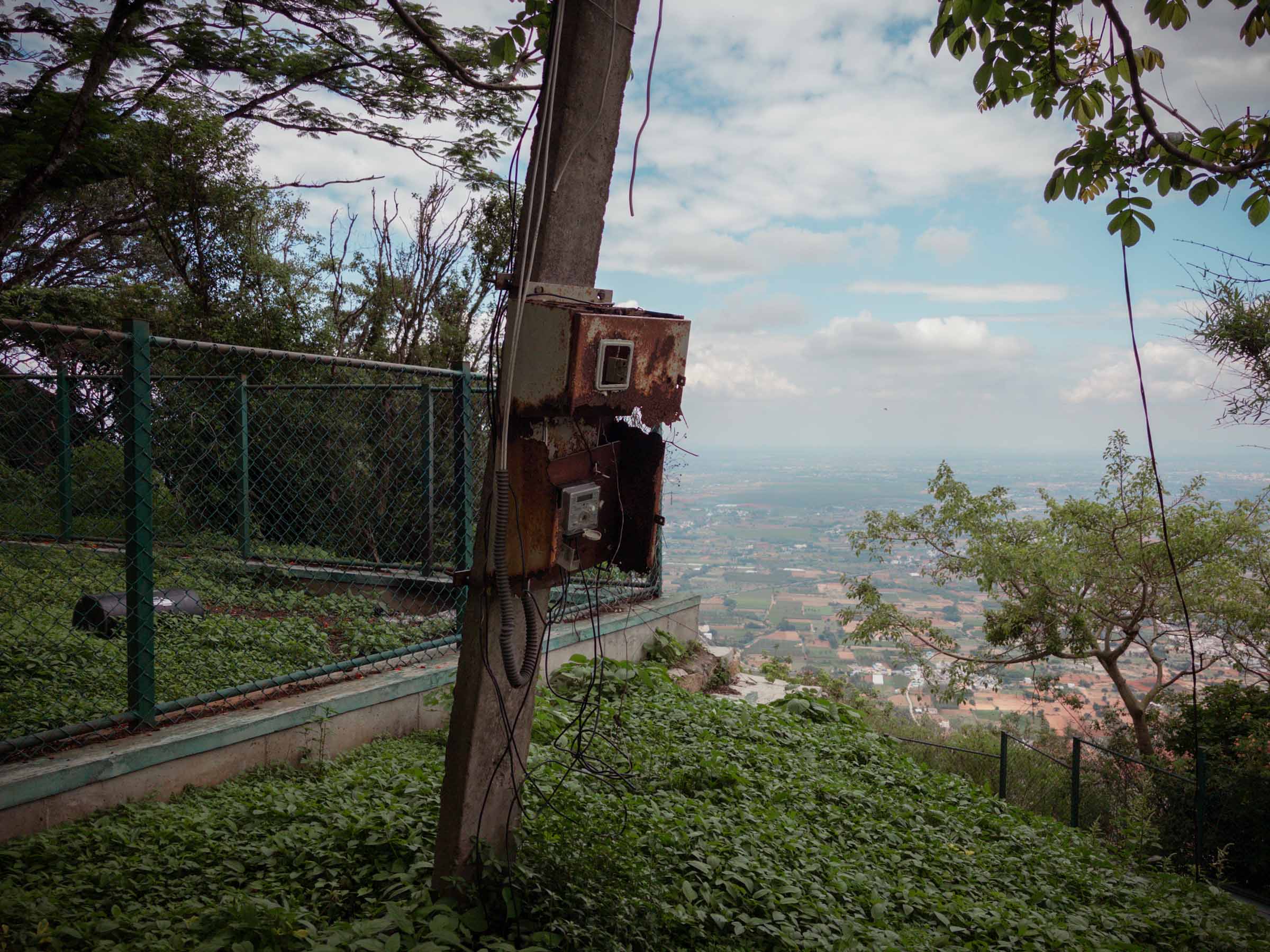Rusted communications equipment bolted to a pole, the plains stretching out beyond