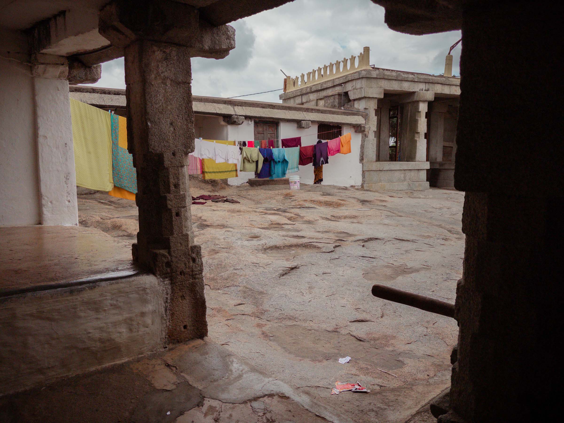 Laundry strung up to dry across a stone temple courtyard on the hilltop