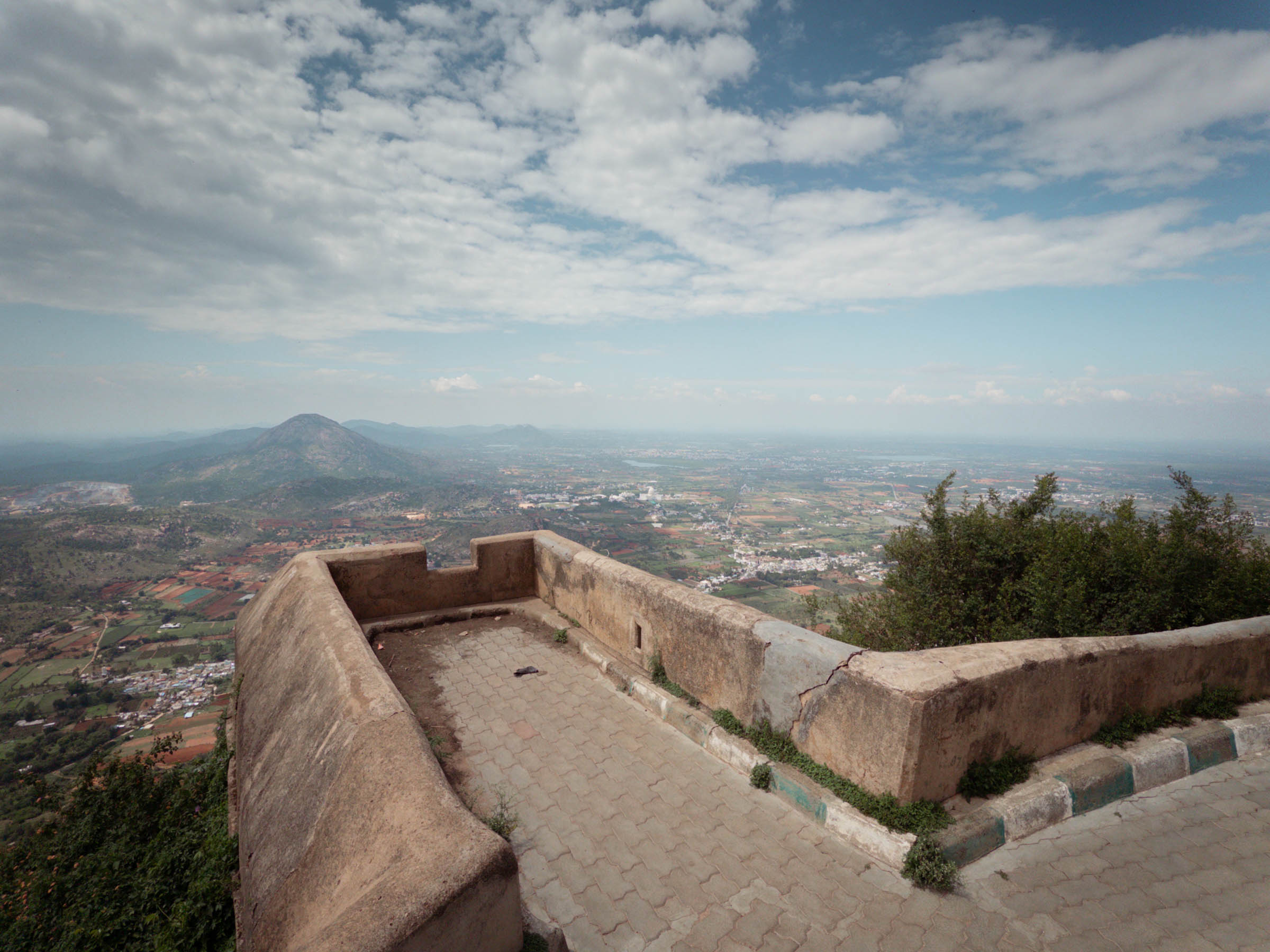 A stone-walled viewpoint at the cliff's edge, overlooking the plains