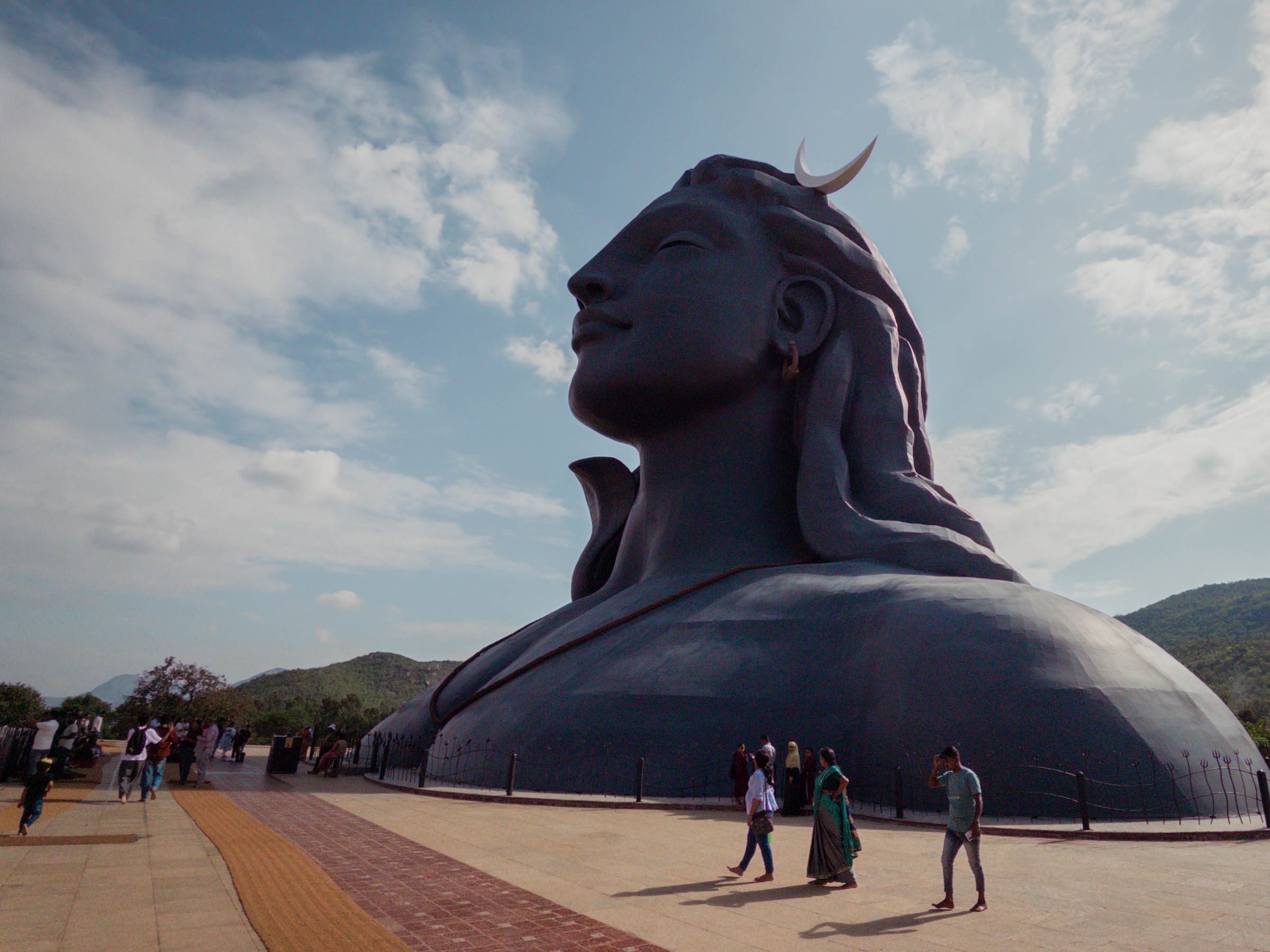 The colossal Adiyogi Shiva bust, crowned with a crescent moon, dwarfing the people below