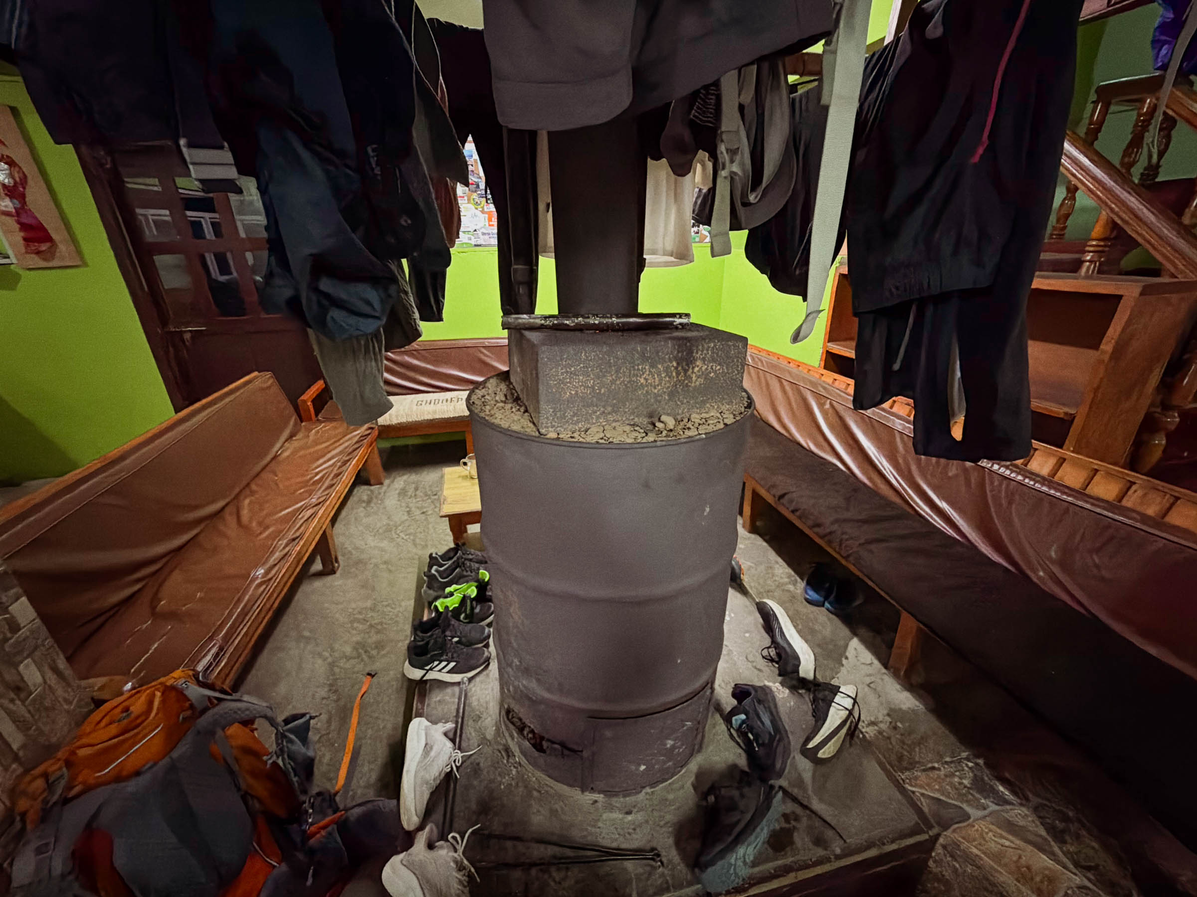 Wet trekking gear drying around a wood stove