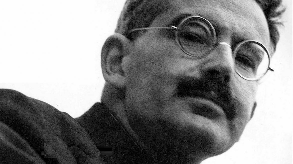 Black and white portrait photo of Walter Benjamin, with a moustache and round glasses