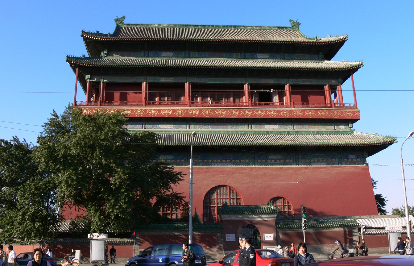 The Beijing Drum Tower, a multi-storied red wooden structure on a stone base, against a blue sky